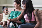 Affectionate couple with lesbian daughter on living room sofa