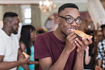 Portrait smiling teenage boy eating pizza with family