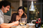 Couple eating with chopsticks and drinking white wine in apartment kitchen