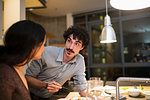 Couple eating dinner with chopsticks in apartment kitchen