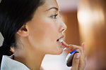 Close up young woman applying lip balm