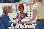 Young women friends enjoying lunch at sunny sidewalk cafe