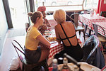 Young women friends dining in restaurant