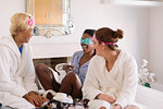 Young women friends wearing eye masks in bedroom