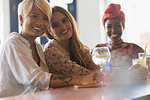 Portrait smiling young women friends drinking cocktails in bar