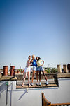 Young women friends taking selfie with camera phone on sunny rooftop
