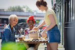 Young women friends enjoying dim sum lunch at sunny sidewalk cafe