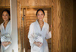 Portrait young woman in bathrobe standing in spa doorway