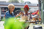 Happy young women friends enjoying dim sum lunch at sunny sidewalk cafe