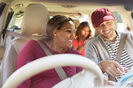 Couple on road trip, looking at map in car