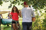 Father and daughter carrying canoe oars