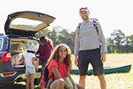 Portrait happy father and daughter camping, unloading car