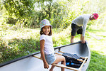 Father and daughter with canoe in woods