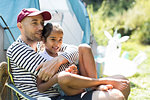 Affectionate father hugging daughter at sunny campsite