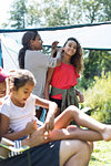 Mother fixing daughters hair at campsite