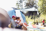 Father and daughter relaxing at campsite