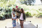 Family catching fish in jar on dock in woods