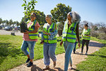 Female volunteers planting tree in sunny park