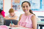 Portrait smiling, confident junior high school girl student doing homework in classroom