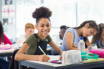 Portrait confident junior high school girl student doing homework in classroom