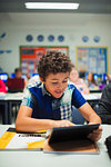 Junior high school boy student using digital tablet in classroom