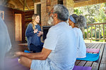 Yoga instructor leading meditation in hut during yoga retreat
