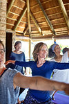 Confident woman practicing warrior 2 pose in hut during yoga retreat