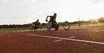 Paraplegic athletes speeding along sports track during wheelchair race