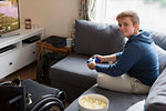 Portrait confident young woman playing video game on sofa next to wheelchair