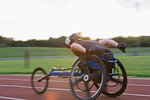 Paraplegic athlete speeding along sports track in wheelchair race