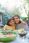 Portrait happy mother an daughter at dinner table