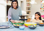 Mother serving dinner to family at dining table