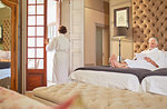 Couple in bathrobes relaxing in hotel room