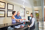 Mature couple checking in at hotel reception