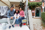 Portrait happy family drinking tea at back of moving van outside new house