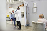 Doctor examining senior male patient in examination room