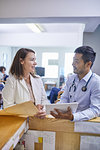 Doctors with digital tablet and medical record talking in clinic