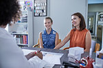 Smiling mother and daughter talking with daughter in clinic doctors office