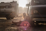 Woman reading beside campervan in desert, Sierra Nevada, Bishop, California, USA