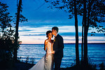 Romantic bride and groom with sparklers by lakeside at dusk, Lake Ontario, Toronto, Canada