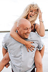 Couple playing piggyback ride on beach