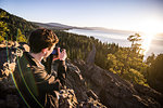 Man taking photographs at sunrise, Lake Tahoe, Tahoe City, California, United States