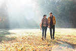 Couple walking in autumnal park, Strandbad, Mannheim, Germany