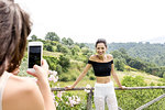 Woman taking photo of friend with view of Città della Pieve, Umbria, Italy