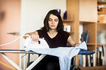 Woman in wheelchair ironing