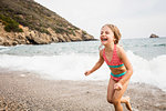 Cute girl running on beach, Portoferraio, Tuscany, Italy