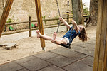 Barefoot girl on playground swing, Portoferraio, Tuscany, Italy