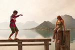 Young couple fooling around on pier, Lake Annecy, Annecy, Rhone-Alpes, France