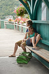 Young couple relaxing on pier bench, Lake Annecy, Annecy, Rhone-Alpes, France