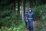 Young hiking couple hiking through forest in hooded anoraks, Manigod, Rhone-Alpes, France